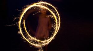 A young girl safely playing with a sparkler on Bonfire Night.